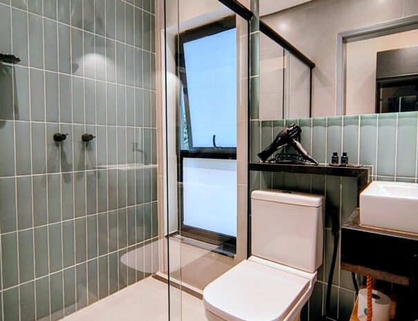 Banheiro moderno e super bem cuidado, com box de vidro e acabamento clean — perfeito para relaxar depois da praia e da cachoeira.