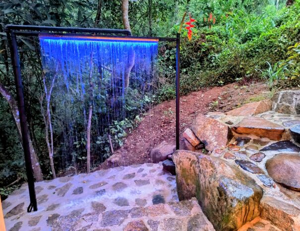 Cascata fria em inox com LED no pátio: um banho gelado revigorante, a poucos passos da suíte — e um cenário lindo para fotos.