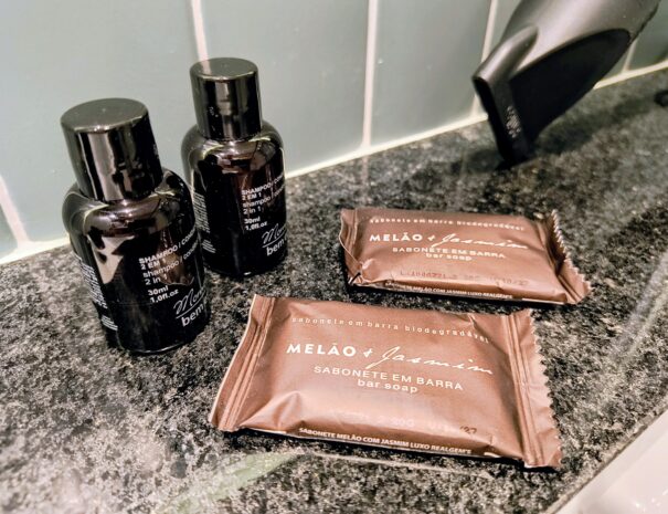 Amenidades de boas-vindas: shampoo e sabonete com aroma melão & jasmim — praticidade desde o primeiro banho.