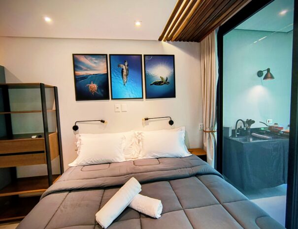 Quarto com cama queen e clima acolhedor — perfeito para descansar depois da praia e da cachoeira.