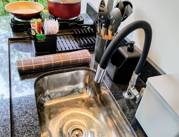 Cozinha compacta e completa: cooktop 2 bocas, pia e utensílios para preparar refeições rápidas sem complicação.