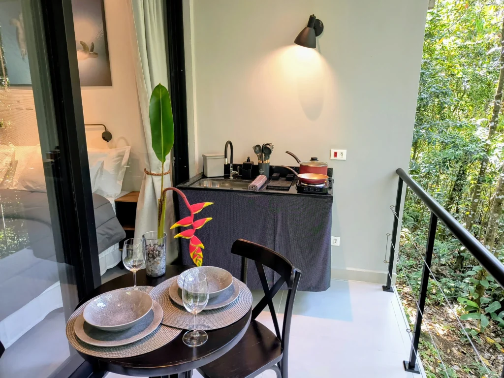 Varanda gourmet cercada pela Mata Atlântica — perfeita para café, vinho e descanso.